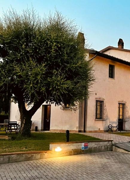 Casa rustica con giardino, tavoli all'aperto e illuminazione serale accogliente.