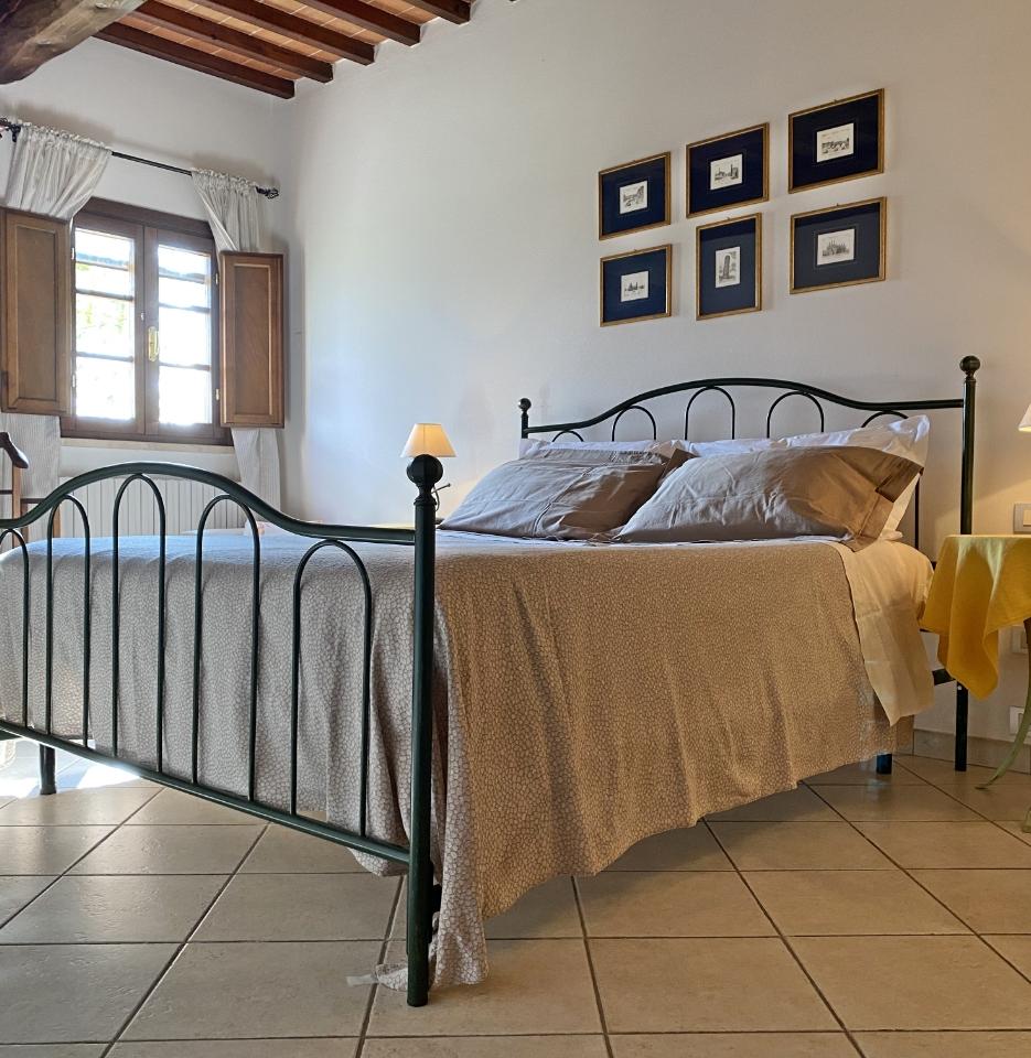 Camera accogliente con letto matrimoniale, lampada e decorazioni alle pareti.