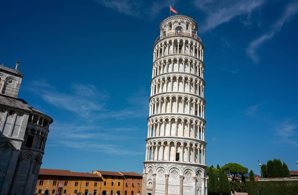 La Torre di Pisa, famosa per la sua inclinazione, sotto un cielo azzurro.