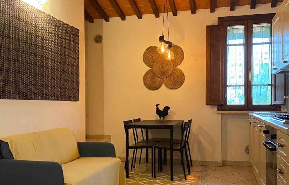 Accogliente cucina con tavolo nero, decorazioni rustiche e soffitto in legno.