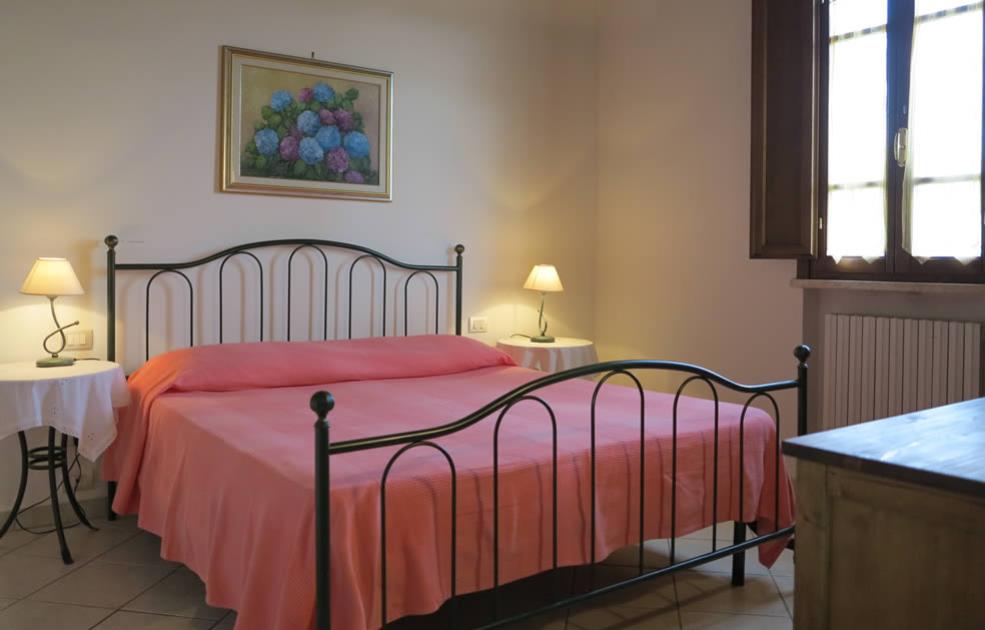 Camera da letto accogliente con letto matrimoniale e decorazioni floreali.